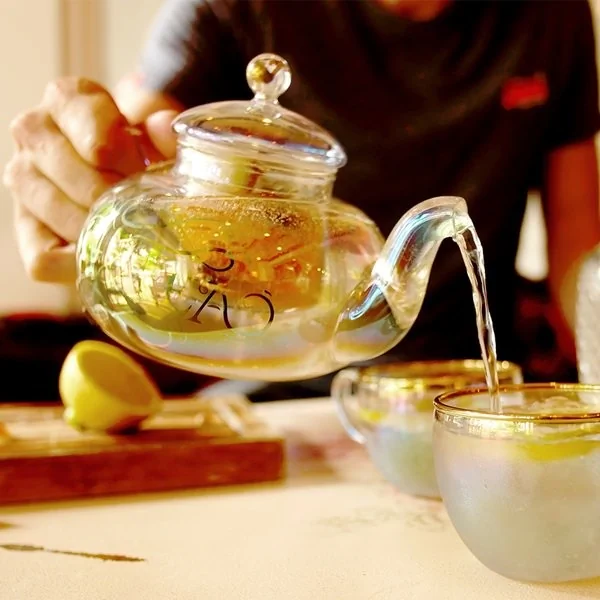 Glass teapot and teacup with gold details