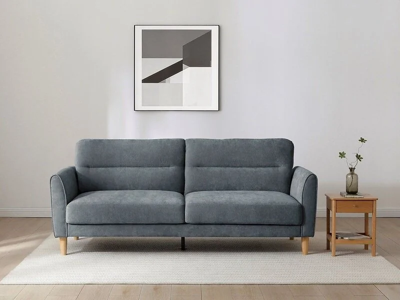 Kyoto Harvey three-seater sofa bed in denim chenille with curved piped arms  a seamed backrest and light wood legs.